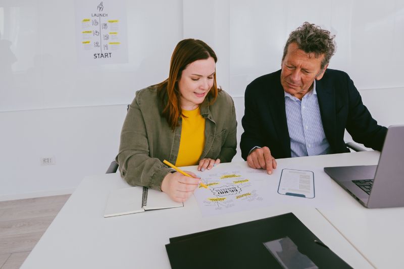 woman teaching business process to a co-worker