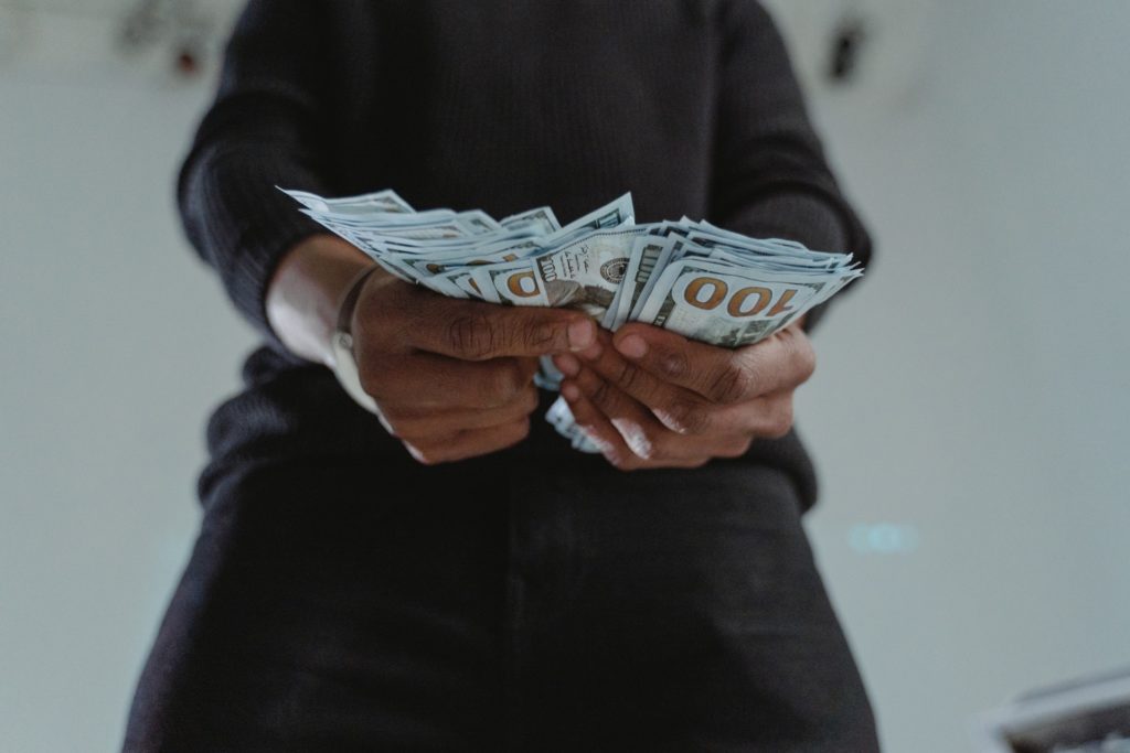 Close-Up Photo of a Person's Hands Holding Dollar Bank Notes