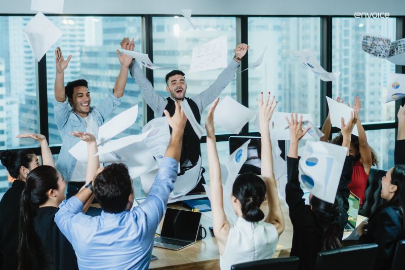 Team celebrating transition to paperless accounts payable, symbolizing the success of digitizing invoicing and payment processes in the office