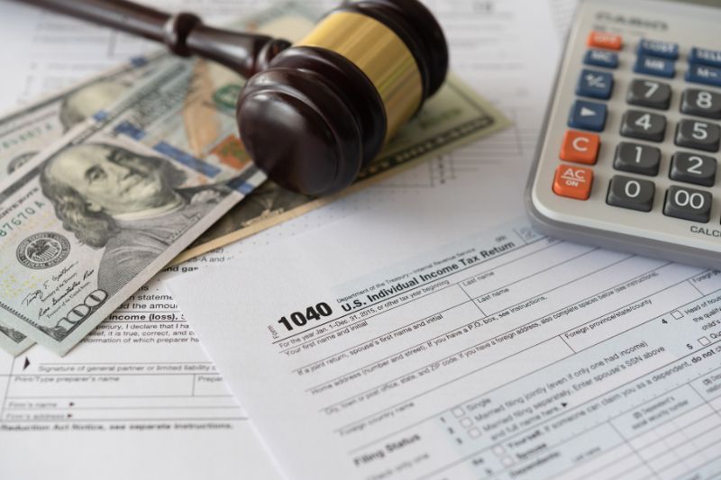 accounting papers, money, calculator, and gavel on table