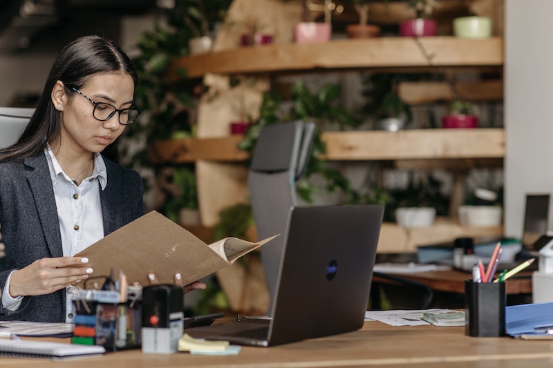 Woman Holding a Brown Folder while Working in the Office