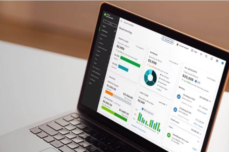 A laptop displaying QuickBooks dashboard for financial management and expense tracking insights.