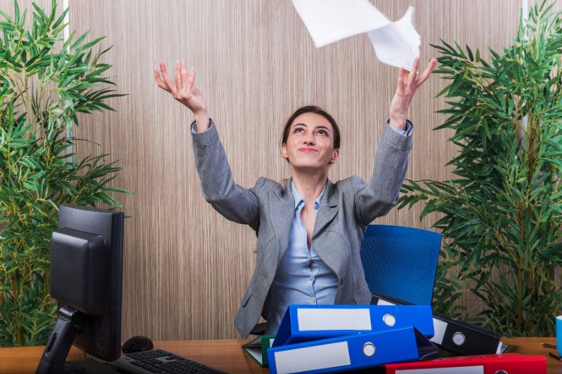 woman smiling while throwing papers