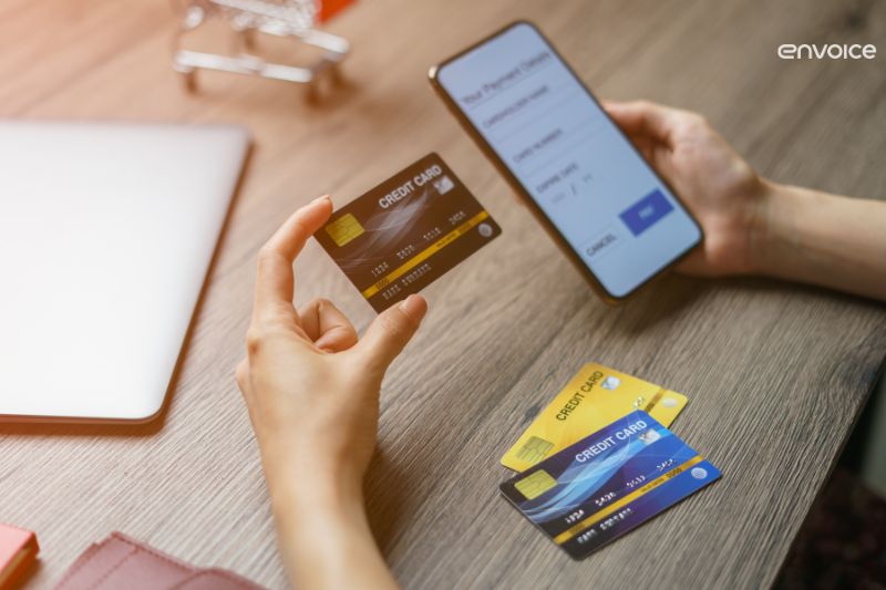 A person making an online payment using a credit card and smartphone.