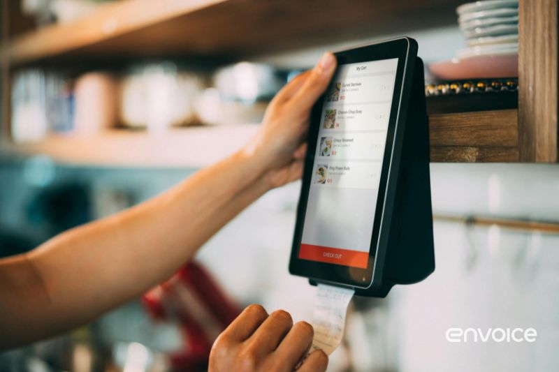 A person using a tablet to print a receipt in a small business setting