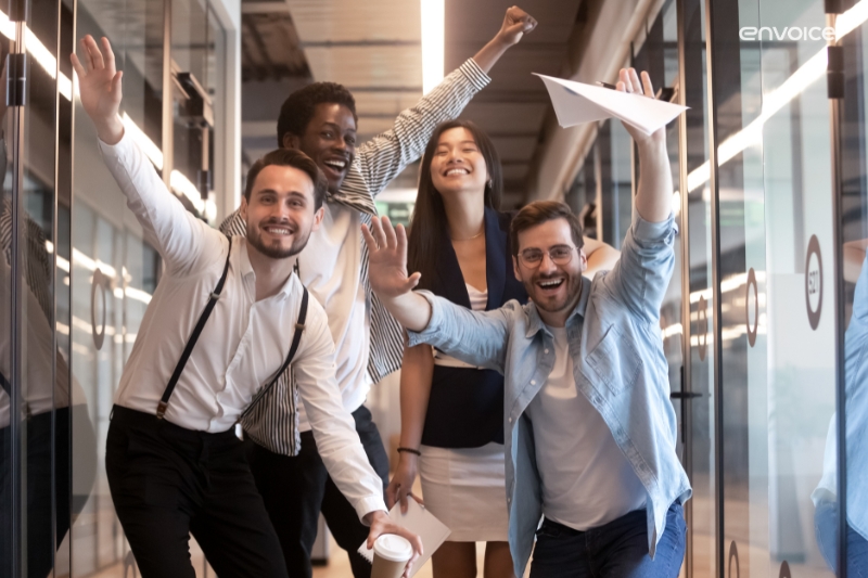 Excited team celebrating success in a modern office, symbolising the benefits of efficient cloud-based accounts payable solutions.