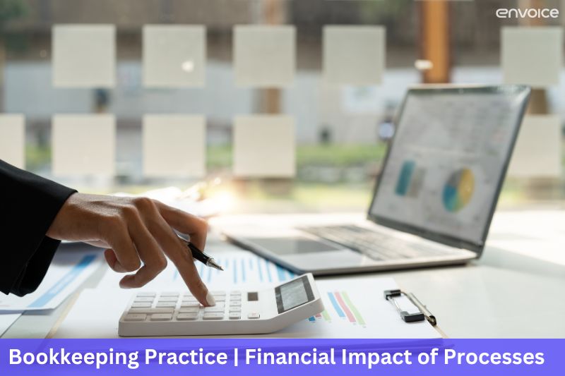 Close-up of a person using a calculator with financial charts and a laptop in the background, representing the financial impact of efficient bookkeeping processes.