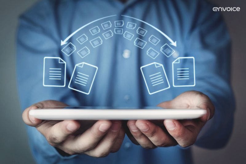Hands holding a tablet with digital invoice icons—invoice recognition software for smart automation in 2025.