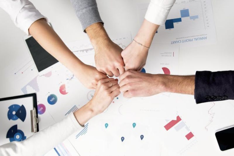 Team unity over financial charts, showing how AP scanning solutions add value to your business processes.