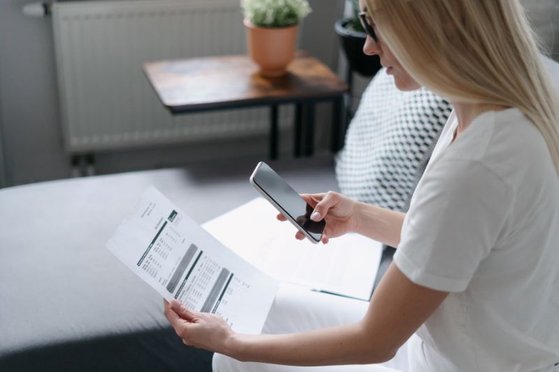 Woman scanning invoice with phone, showing how AP scanning solutions add value to your business