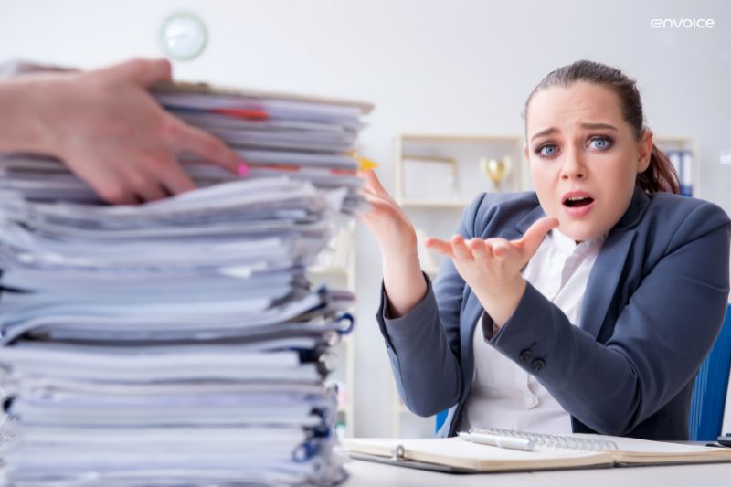 Overwhelmed employee buried in paperwork, highlighting need for AP automation machine learning solutions.